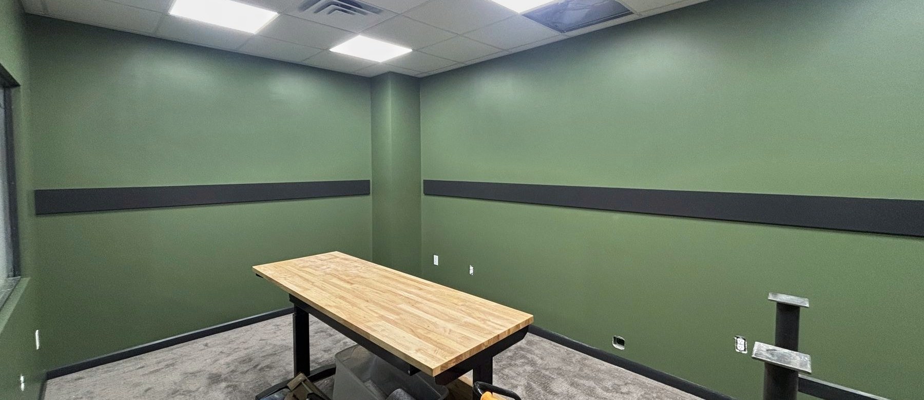 Office painted green with a charcoal accent stripe